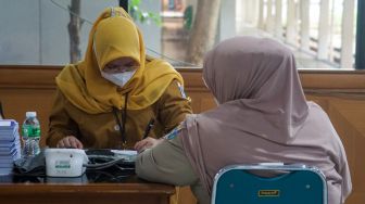 Warga mendapatkan vaksinasi booster Covid-19 kedua di Kantor Wali Kota Jakarta Timur, Selasa (24/1/2023). [Suara.com/Alfian Winanto]