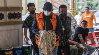 Penyidik Komisi Pemberantasan Korupsi (KPK) menggiring buronan Izil Azhar alias Ayah Merin (tengah) saat tiba di Bandara Internasional Sultan Iskandar Muda (SIM) Aceh Besar, Aceh, Rabu (25/1/2023). [ANTARA FOTO/Khalis Surry].