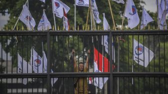 Seorang perangkat desa dari Persatuan Perangkat Desa Indonesia (PPDI) berdiri di balik pagar saat melakukan unjuk rasa di depan Gedung DPR, Senayan, Jakarta, Rabu (25/1/2023). [ANTARA FOTO/Galih Pradipta].