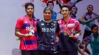 Pebulu tangkis tunggal putra Indonesia Jonatan Christie (kanan) dan Chico Aura Dwi Wardoyo (kiri) dan pelatih mereka, Irwansyah (tengah) berpose dengan medali juara tunggal putra turnamen bulutangkis Daihatsu Indonesia Masters 2023 di Istora Senayan, Jakarta, Minggu (29/1/2023). [Suara.com/Alfian Winanto]