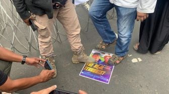 Massa yang tergabung dalam PA 212 injak poster wajah Rasmus Paludan dan Pegida Edwin Wagensveld saat aksi di depan Kedutaan Besar (Kedubes) Swedia, Kuningan, Jakarta Selatan pada Senin (30/1/2023). [Suara.com/Yamual]