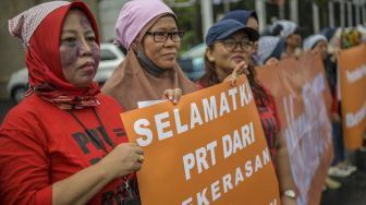 Pengunjuk rasa yang tergabung dalam Koalisi Sipil untuk UU PPRT menggelar aksi teaterikal di depan gedung DPR, Jakarta, Rabu (1/2/2023). [ANTARA FOTO/Galih Pradipta].