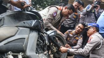 Sejumlah polisi melakukan pengecekan motor yang digunakan mahasiswa UI Mohammad Hasya saat kecelakaan di Jalan Srengseng Sawah, Jagakarsa, Jakarta Selatan, Kamis (2/2/2023). [ANTARA FOTO/Asprilla Dwi Adha].