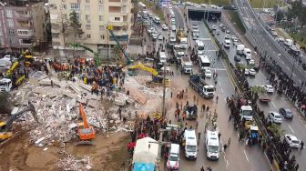 Tim penyelamat mencari korban selamat di puing-puing bangunan yang runtuh akibat gempa bumi di Sanliurfa, Turki, Senin (6/2/2023). [AFP]