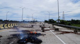 Sejumlah warga melakukan aksi menutup akses jalan menuju Gerbang Tol (GT) Jatikarya 1 dan 2, di ruas Jalan tol Cimanggis-Cibitung, Bekasi, Jawa Barat, Rabu (8/2/2023). [Suara.com/Alfian Winanto]