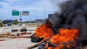 Sejumlah warga melakukan aksi menutup akses jalan menuju Gerbang Tol (GT) Jatikarya 1 dan 2, di ruas Jalan tol Cimanggis-Cibitung, Bekasi, Jawa Barat, Rabu (8/2/2023). [Suara.com/Alfian Winanto]