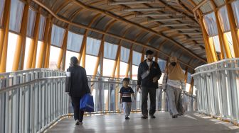 Sejumlah pejalan kaki melintasi Skywalk di kawasan Kebayoran Lama, Jakarta Selatan, Jumat (10/2/2023). [Suara.com/Alfian Winanto]