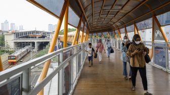 Sejumlah pejalan kaki melintasi Skywalk di kawasan Kebayoran Lama, Jakarta Selatan, Jumat (10/2/2023). [Suara.com/Alfian Winanto]