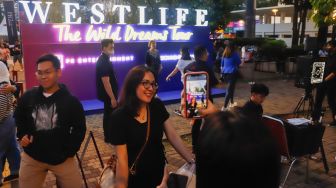 Penonton berswafoto saat menghadiri konser Westlife 'The Wild Dreams Tour' di Stadion Madya, Gelora Bung Karno, Jakarta Pusat, Sabtu (11/2/2023). [Suara.com/Alfian Winanto]