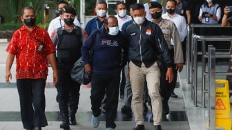 Tersangka kasus dugaan suap dan gratifikasi di Kabupaten Mamberamo Tengah, Papua, Ricky Ham Pagawak (tengah) tiba untuk menjalani pemeriksaan di Gedung Merah Putih KPK, Jakarta Selatan, Senin (20/2/2023). [Suara.com/Alfian Winanto]