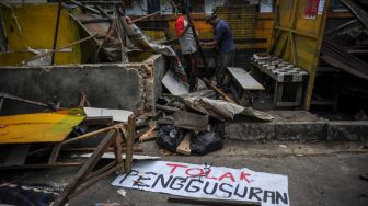 Petugas Satpol PP menggunakan alat berat untuk merobohkan bangunan liar di Jalan Cijagra, Bandung, Jawa Barat, Kamis (23/2/2023). [ANTARA FOTO/Raisan Al Farisi].