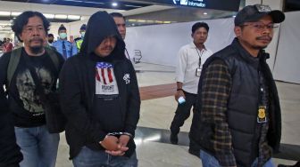 Anggota polisi Resmob Polda Metro Jaya membawa seorang debt collector pelaku pemaki petugas kepolisian Lesly Watimena (tengah) setibanya dari Ambon di Terminal 2 Bandara Soekarno Hatta, Tangerang, Banten, Kamis (23/02/2023). [ANTARA FOTO/Muhammad Iqbal].