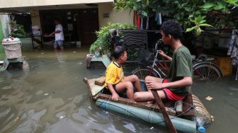 Sejumlah warga melintasi genangan banjir di Rawa Buaya, Cengkareng, Jakarta Barat, Senin (27/2/2023).  [ANTARA FOTO/Prabanndaru Wahyuaji].