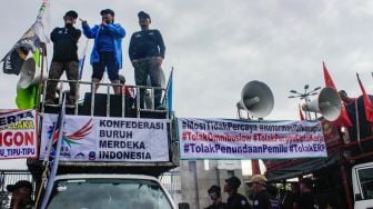 Massa dari sejumlah elemen Buruh, Mahasiswa dan Pekerja saat menggelar aksi demo menolak Perppu Cipta Kerja di depan gedung DPR/MPR RI, Senayan, Jakarta Pusat, Selasa (28/2/2023). [Suara.com/Alfian Winanto]