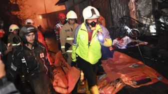 Sejumlah petugas mengevakuasi korban meninggal kebakaran Depo Pertamina Plumpang,kawasan Jalan Koramil, Rawa Badak Selatan, Koja, Jakarta Utara, Jumat (3/3/2023). [ANTARA FOTO/M Risyal Hidayat].
