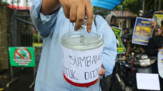 Massa melakukan aksi simbolik &#039;Koin Peduli untuk Ditjen Pajak&#039; di depan Kantor Direktorat Jendral Pajak, Senayan, Jakarta Selatan, Kamis (3/3/2023). [Suara.com/Alfian Winanto]