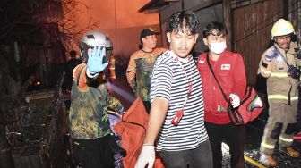 Petugas mengevakuasi jenazah korban kebakaran Depo Pertamina Plumpang di kawasan Jalan Koramil, Rawa Badak Selatan, Koja, Jakarta Utara, Jumat (3/3/2023). [ANTARA FOTO/M Risyal Hidayat].