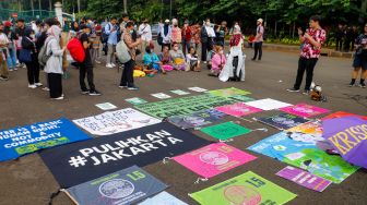 Sejumlah aktivis saat menggelar aksi unjuk rasa terkait krisis iklim di Kawasan Patung Kuda, Jakarta Pusat, Jumat (3/3/2023). [Suara.com/Alfian Winanto]