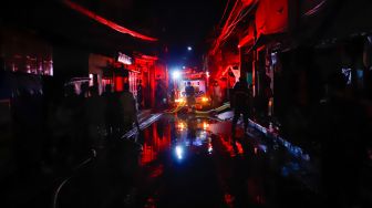 Sejumlah petugas berusaha memadamkan api yang membakar rumah warga imbas kebakaran Depo Pertamina Plumpang, Koja, Jakarta Utara, Jumat (3/3/2023). [Suara.com/Alfian Winanto]
