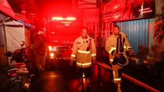Sejumlah petugas berusaha memadamkan api yang membakar rumah warga imbas kebakaran Depo Pertamina Plumpang, Koja, Jakarta Utara, Jumat (3/3/2023). [Suara.com/Alfian Winanto]