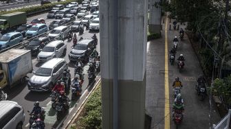 Pengendara sepeda motor melintas di atas trotoar Jalan Gatot Subroto, Jakarta, Senin (6/3/2023). [ANTARA FOTO/Aprillio Akbar].