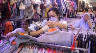 Calon pembeli memilih pakaian impor bekas di Pasar Senen, Jakarta Pusat, Selasa (7/3/2023). [Suara.com/Alfian Winanto]