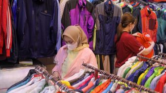 Calon pembeli memilih pakaian impor bekas di Pasar Senen, Jakarta Pusat, Selasa (7/3/2023). [Suara.com/Alfian Winanto]