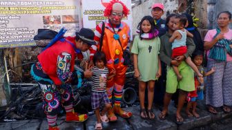 Sejumlah Badut yang tergabung dalam komunitas Aku Badut Indonesia (ABI) menghibur anak-anak di sekitar lokasi kebakaran Depo Pertamina Plumpang di Koja, Jakarta Utara, Rabu (8/3/2023). [Suara.com/Alfian Winanto]