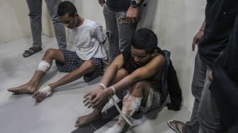 Petugas kepolisian berpakaian preman menjaga dua orang narapidana (napi) Pancareno Ramekencana (19) (kiri) dan Jihat Aji Nurmono (26) (kanan) yang berhasil ditangkap usai melarikan diri dari Lapas IIA Palangka Raya saat rilis penangkapan napi di RS Bhayangkara, Palangka Raya, Kalimantan Tengah, Selasa (7/3/2023). [ANTARA FOTO/Makna Zaezar].