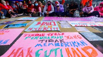 Para peserta melakukan aksi di sekitar Patung Kuda Arjuna Wiwaha, Jakarta Pusat, Rabu (8/3/2023). [Suara.com/Alfian Winanto]