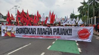 Ribuan massa aksi yang tergabung dalam Gerakan Buruh Bersama Rakyat (Gebrak) menggeruduk di depan Gedung DPR RI, Senayan, Jakarta, pada Selasa (14/3/2023). [Suara.com/Faqih]