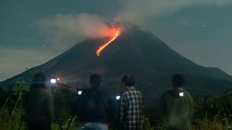 Sejumlah orang mengabadikan guguran lava pijar Gunung Merapi yang terlihat dari Turi, Sleman, DI Yogyakarta, Selasa (14/3/2023). [ANTARA FOTO/Andreas Fitri Atmoko].