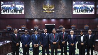 Ketua dan Wakil Ketua Mahkamah Konstitusi terpilih periode 2023-2028 Anwar Usman (keempat kiri) dan Saldi Isra (keempat kanan) berpose bersama sejumlah hakim konstitusi usai pemilihan di gedung MK, Jakarta, Rabu (15/3/2023). [ANTARA FOTO/Akbar Nugroho Gumay].