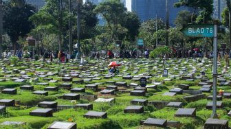 Warga melakukan ziarah makam di TPU Menteng Pulo, Jakarta Pusat, Jumat (17/3/2023). [Suara.com/Alfian Winanto]
