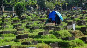 Warga melakukan ziarah makam di TPU Menteng Pulo, Jakarta Pusat, Jumat (17/3/2023). [Suara.com/Alfian Winanto]