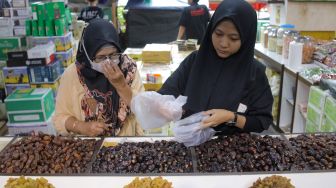 Pembeli memilih kurma yang dijual di kawasan Tanah Abang, Jakarta Pusat, Sabtu (25/3/2023). [Suara.com/Alfian Winanto]