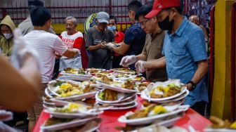 Pengurus vihara membagikan makanan berbuka puasa untuk warga di Vihara Dharma Bakti, Jakarta Barat, Rabu (29/3/2023). [Suara.com/Alfian Winanto]