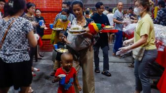 Pengurus vihara membagikan makanan berbuka puasa untuk warga di Vihara Dharma Bakti, Jakarta Barat, Rabu (29/3/2023). [Suara.com/Alfian Winanto]