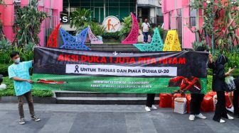 Sejumlah pecinta sepak bola mengadakan aksi di kawasan Jalan Jenderal Sudirman, Jakarta Pusat, Jumat (31/3/2023). [Suara.com/Alfian Winanto]
