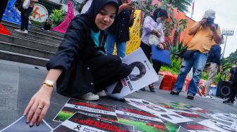 Sejumlah pecinta sepak bola mengadakan aksi di kawasan Jalan Jenderal Sudirman, Jakarta Pusat, Jumat (31/3/2023). [Suara.com/Alfian Winanto]
