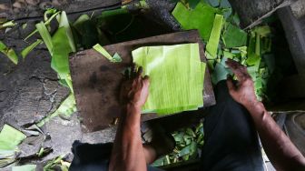 Pekerja menyelesaikan proses pembuatan lemang bambu di kawasan Senen, Jakarta, Jumat (31/3/2023). [Suara.com/Alfian Winanto]