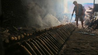 Pekerja menyelesaikan proses pembuatan lemang bambu di kawasan Senen, Jakarta, Jumat (31/3/2023). [Suara.com/Alfian Winanto]