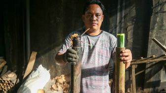 Pekerja menyelesaikan proses pembuatan lemang bambu di kawasan Senen, Jakarta, Jumat (31/3/2023). [Suara.com/Alfian Winanto]