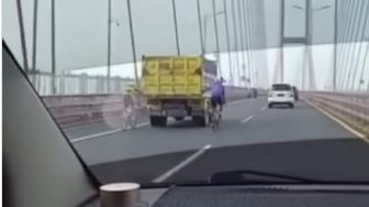 Viral Dua Pesepeda 'Gandol' Belakang Truk di Jembatan Suramadu, Warganet: Beban Jalanan