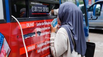 Warga menukarkan uang tunai baru di layanan kas keliling Bank Indonesia di Pasar Tebet Barat Jakarta Selatan, Selasa (4/4/2023). [Suara.com/Alfian Winanto]
