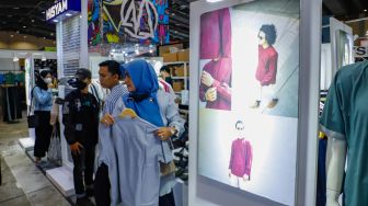 Pengunjung memilih pakaian yang dijual dalam JakCloth Ramadan 2023 di Hall B Jakarta Convention Center (JCC), Senayan, Jakarta, Sabtu (8/4/2023). [Suara.com/Alfian Winanto]