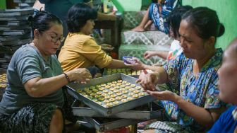 Pekerja menyelesaikan pembuatan kue kering di kawasan Kwitang, Jakarta, Rabu (12/4/2023). [Suara.com/Alfian Winanto]