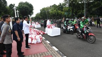 Presiden Joko Widodo atau Jokowi bersama Menteri BUMN Erick Thohir menyaksikan pembagian sembako untuk ojek online di depan Istana Merdeka, Jakarta, Kamis (13/4/2023). [Foto: Kris - Biro Pers Sekretariat Presiden]