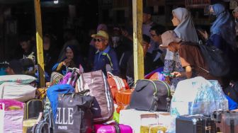 Penumpang bersiap menanti kedatangan bus di Terminal Pondok Pinang, Jakarta Selatan, Kamis (13/4/2023). [Suara.com/Alfian Winanto]