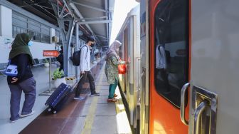 Penumpang menaiki Kereta Api di Stasiun Pasar Senen, Jakarta Pusat, Senin (17/4/2023). [Suara.com/Alfian Winanto]